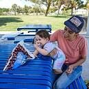 a mother and child sitting at a bench