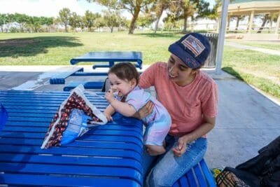 a mother and child sitting at a bench