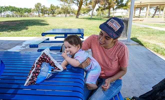 a mother and child sitting at a bench