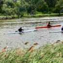The image is of three kayakers paddling along a river