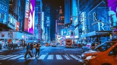 nighttime view of a new york street with people crossing in a crosswalk