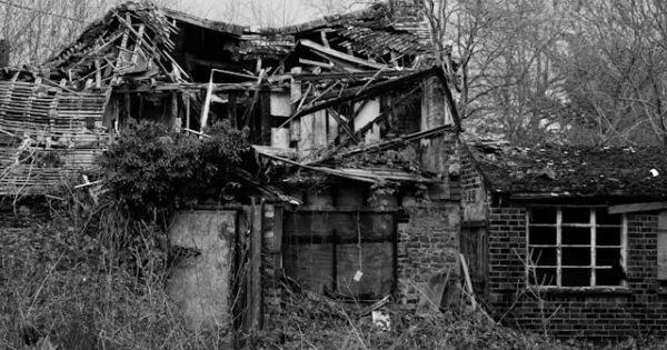 Black and white photo of a dilapidated house