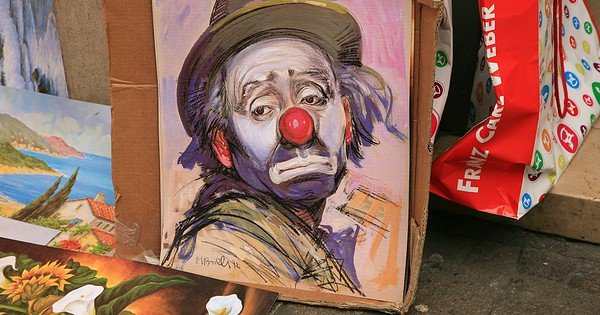 A painting of a sad man in clown makeup