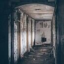 a decrepit hallway with debris in the floor