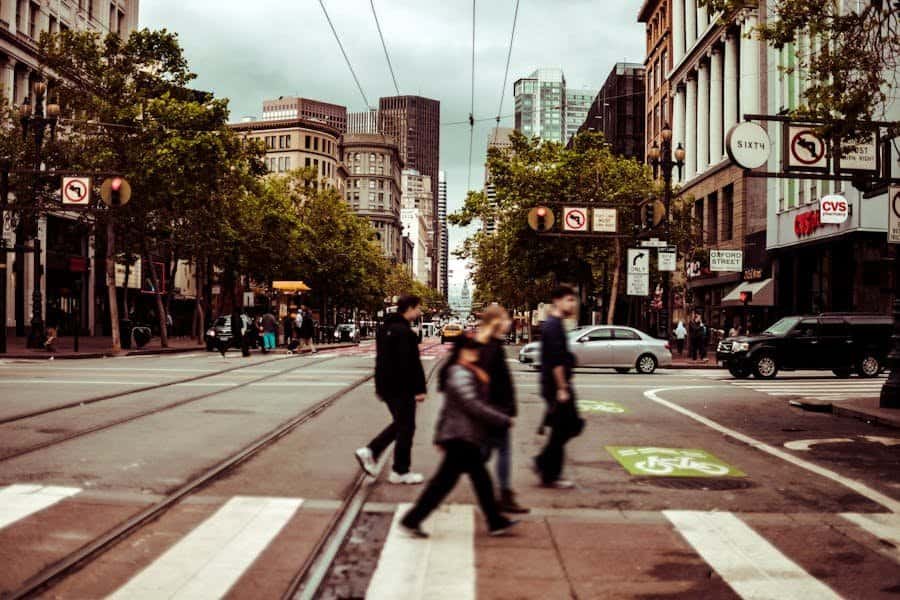 people walking across a crosswalk on a city street.