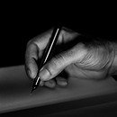 Black and white photo of male hand holding a black pen