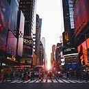 Time Square in New York with a group of people crossing the street.