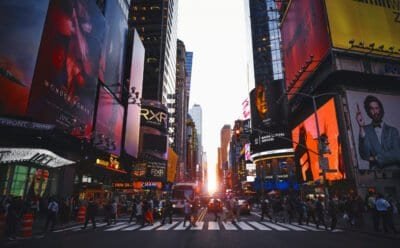 Time Square in New York with a group of people crossing the street.