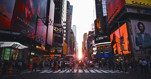 Time Square in New York with a group of people crossing the street.