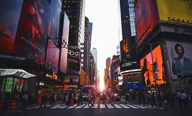 Time Square in New York with a group of people crossing the street.