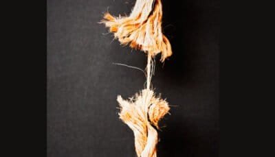 Frayed rope hanging on by a thread