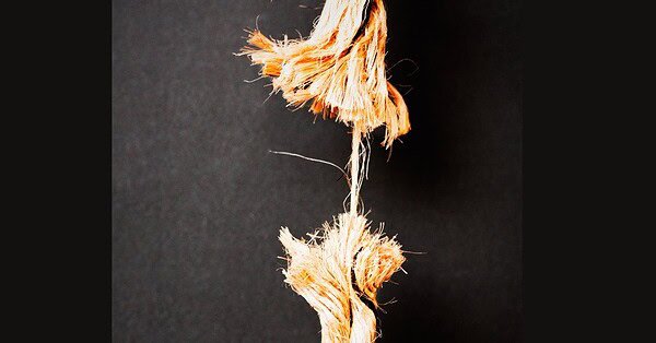 Frayed rope hanging on by a thread