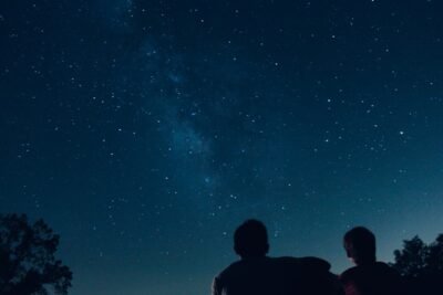 2 people staring at the night sky full of stars