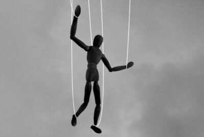 An art doll held by strings.