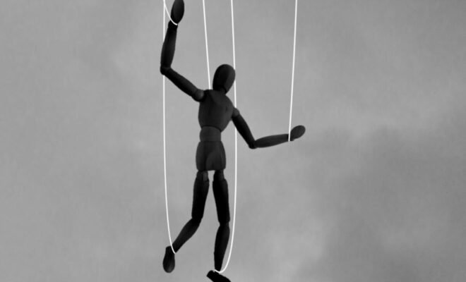 An art doll held by strings.