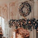 Living room with fireplace decorated with a Christmas tree, garland and wreath.