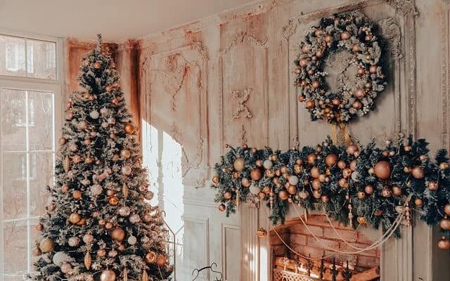 Living room with fireplace decorated with a Christmas tree, garland and wreath.