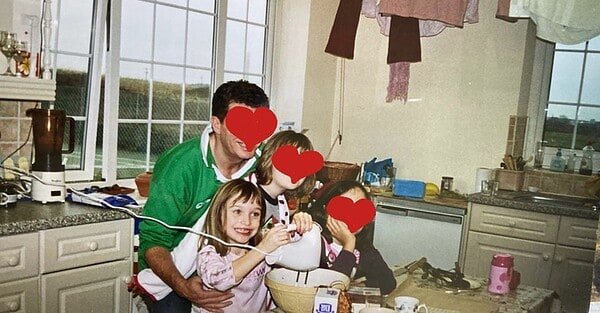 A little girl grinning ecstatically as she whisks up a concoction. Her family are with her and their faces are obscured for privacy.