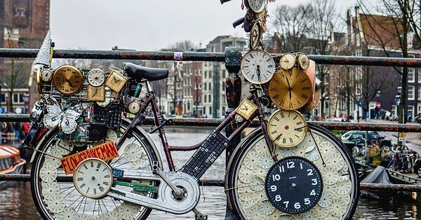 The image is of a weird 'clock' bike on a bridge over river.