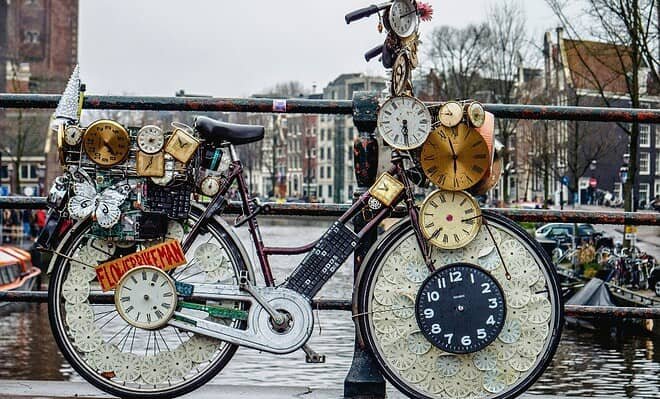 The image is of a weird 'clock' bike on a bridge over river.