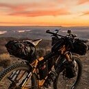 Bike on a hill with a view of a yellow and orange sunset
