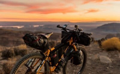 Bike on a hill with a view of a yellow and orange sunset