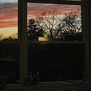 Image of a bedroom window displaying the sunset