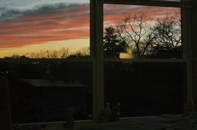 Image of a bedroom window displaying the sunset