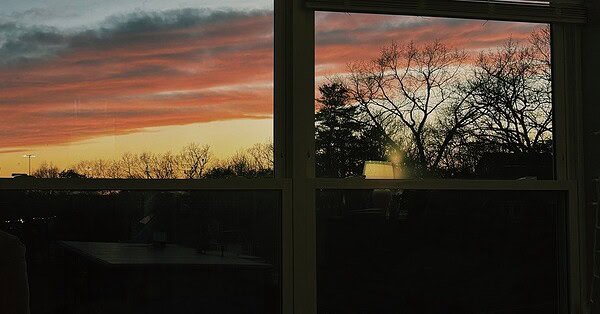 Image of a bedroom window displaying the sunset