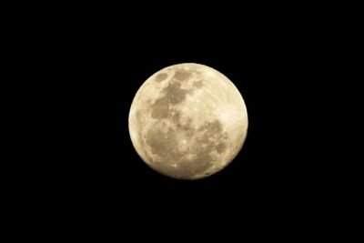 A shining full moon in the middle of an empty midnight sky