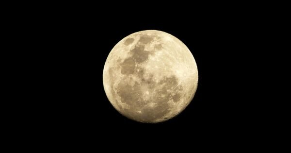 A shining full moon in the middle of an empty midnight sky