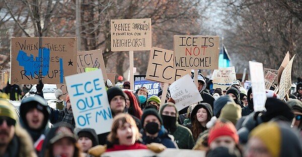 Protesters in Minneapolis gather on the spot where Renee Good was killed, holding signs that read, "When these colonies gonna rise up?", "ICE out of MN", "Renee sparkled! Fight for our neighbors". "Fuck ICE", and "ICE is not welcome (with not emphasized in red)".