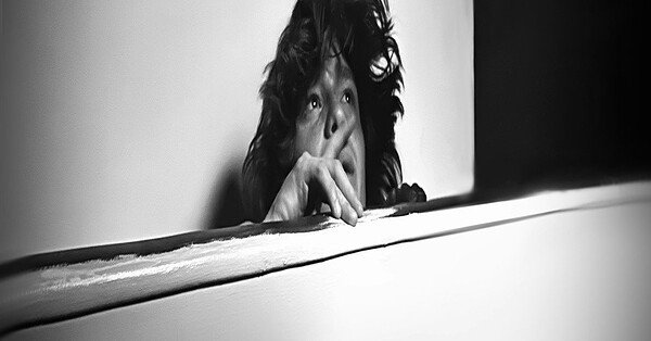 A woman staring off with a black and white background.