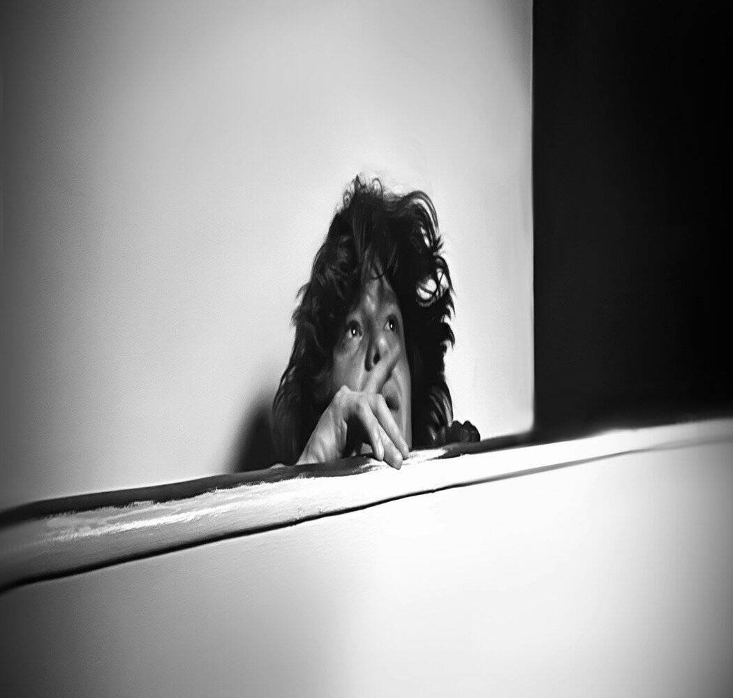 A woman staring off with a black and white background.