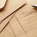 Lined paper with the word "dear" written in cursive and a fountain pen next to it