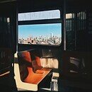 A dark subway car with sun shadows shining on orange and white seats.