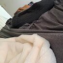 heavily blanketed bed with a dog