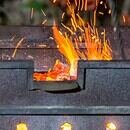 bbq pit with fire and flames flickering up through the grill.