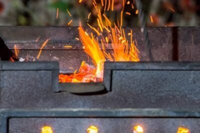 bbq pit with fire and flames flickering up through the grill.