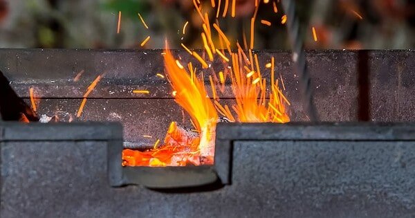 bbq pit with fire and flames flickering up through the grill.