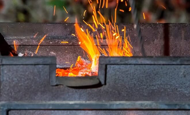 bbq pit with fire and flames flickering up through the grill.