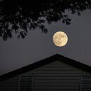 House at night under a full moon.