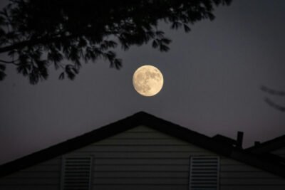 House at night under a full moon.