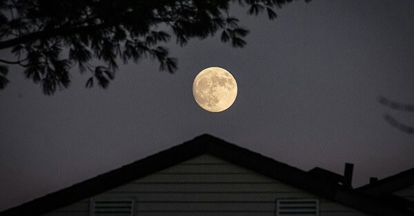 House at night under a full moon.