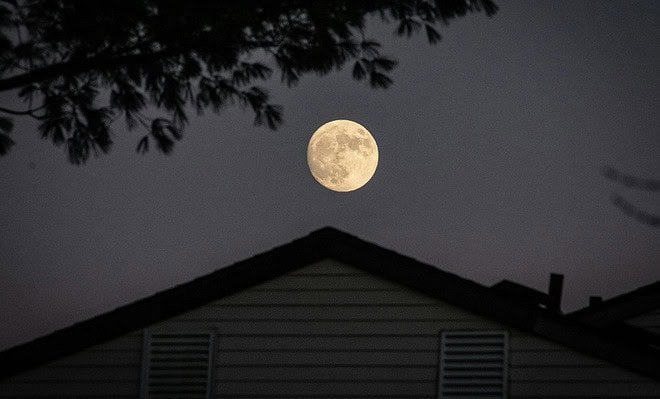 House at night under a full moon.