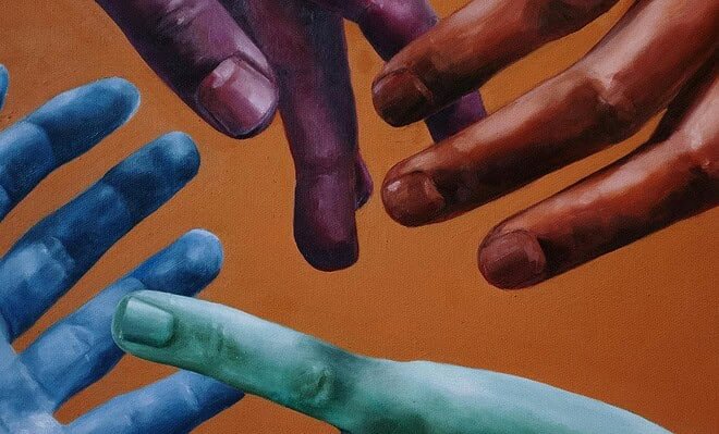 Four multi-colored hands reaching for each other against an orange background