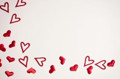 There is a white background with a flurry of hearts filling the left side of the picture, flowing along the bottom towards the bottom right corner of the photo