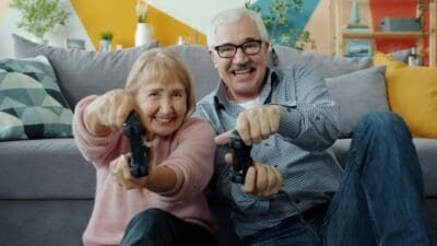 elderly man and woman playing video game.