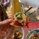 A small mouthful of food is held up to the camera.