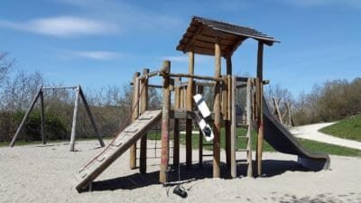 a playground structure in a park with a blue sky background